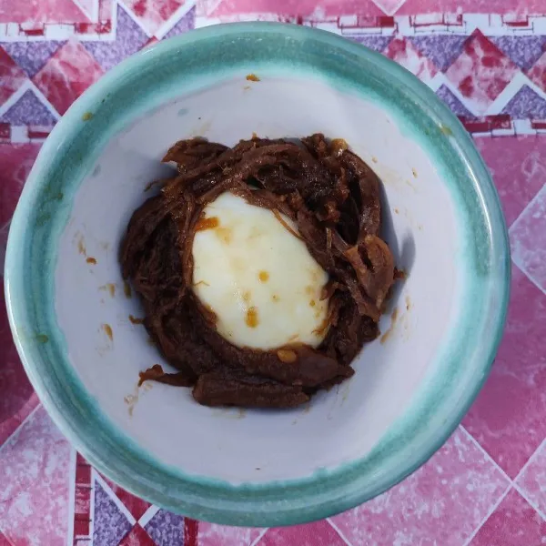 Tata ½ butir telur rebus dan daging suwir di dasar mangkok.