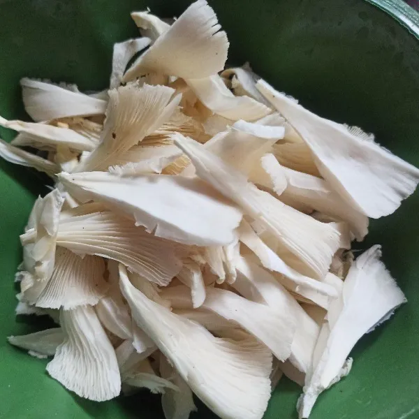 Suwir-suwir jamur tiram kemudian cuci bersih.
