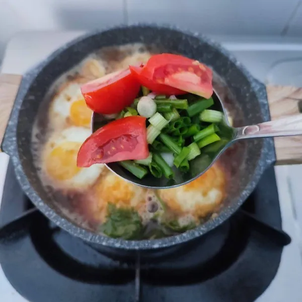 Masukkan irisan daun bawang dan tomat, masak sampai layu. Sajikan selagi hangat.