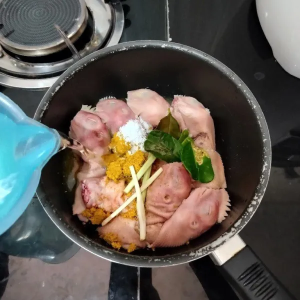 Masukkan kepala ayam ke dalam panci. Tambahkan bumbu ayam goreng, serai, daun jeruk, garam dan air. Aduk rata.