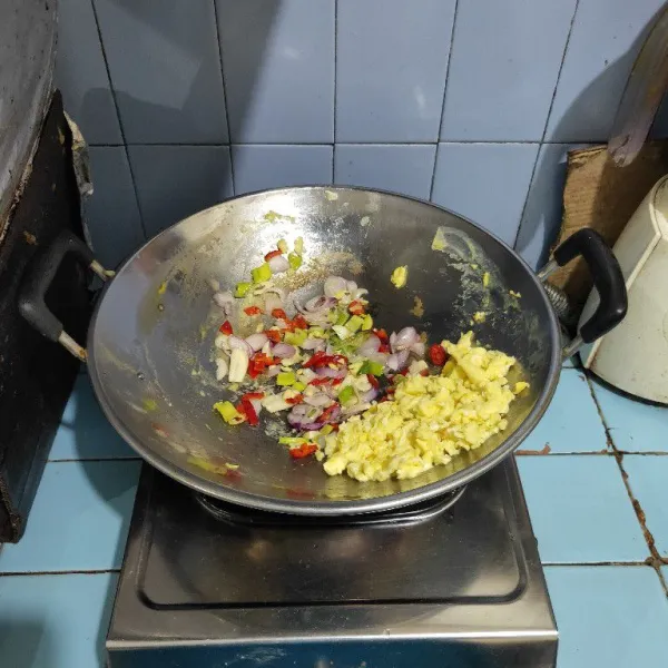 Panaskan minyak, kemudian masukkan telur, aduk orak-arik, lalu sisihkan ke pinggir wajan. Tumis bumbu iris, cabe merah dan daun bawang sampai harum.