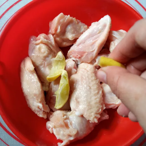 Potong sayap ayam menjadi dua, buang bagian runcingnya. Cuci bersih kemudian kucuri jeruk nipis. Diamkan 5 menit kemudian bilas.