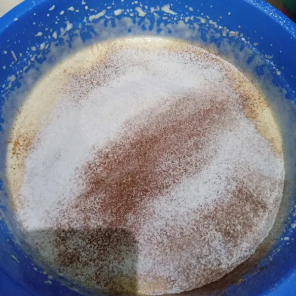 Tambahkan tepung terigu, coklat bubuk dan soda kue yang telah diayak. Mixer sebentar hingga homogen.