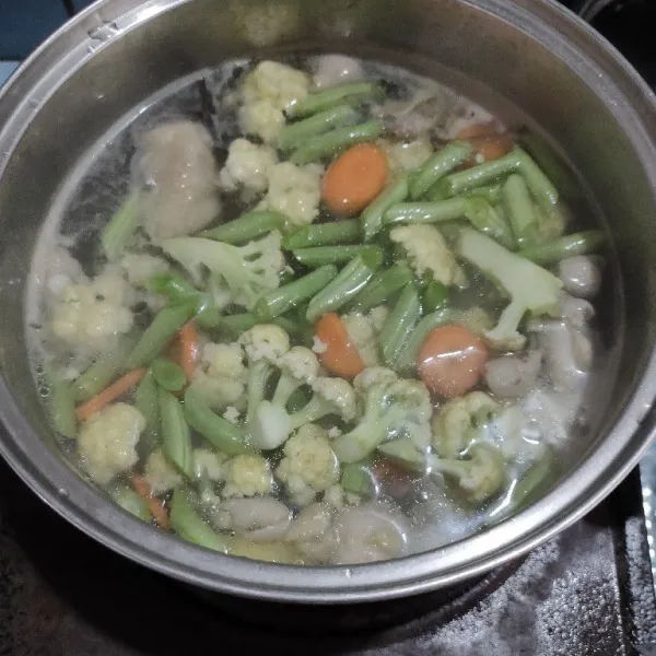 Masukkan kembang kol, wortel, buncis dan juga bumbu halus kedalam rebusan ayam, masak hingga mendidih.