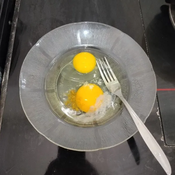 Pecahkan telur dalam piring. Tambahkan merica bubuk, kaldu bubuk dan garam. Lalu kocok hingga tercampur rata.