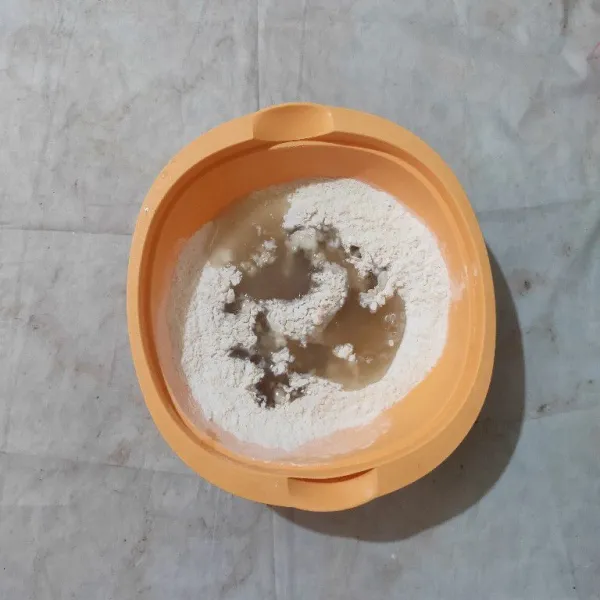 Tuang air rebusan bumbu ke dalam wadah yang berisi campuran tepung.