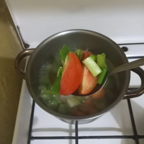 Masukkan irisan daun bawang dan tomat.