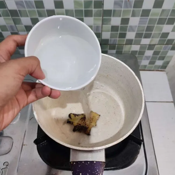 Geprek jahe kemudian masukkan ke dalam milk pan. Lalu tambahkan air, biarkan mendidih.