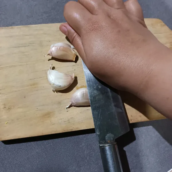 Kemudian tekan bawang putih dengan pisau sampai berbunyi "krek".