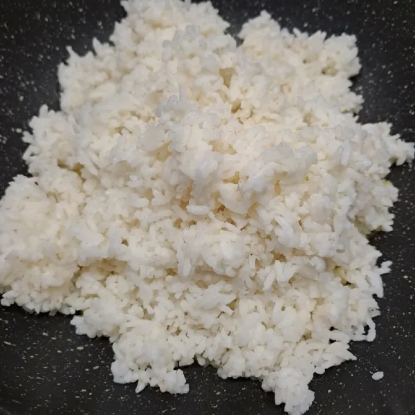 Masukkan nasi putih, aduk sampai rata dengan margarin. Api kompor di posisi nyala besar.