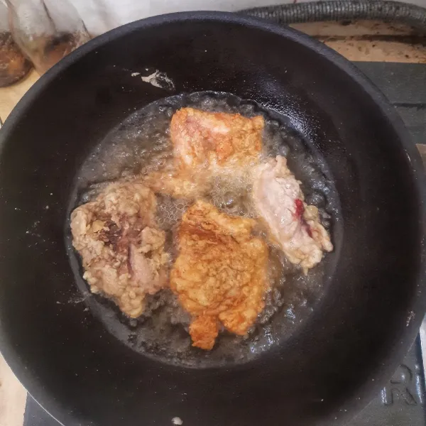 Goreng ayam di minyak panas sampai matang.