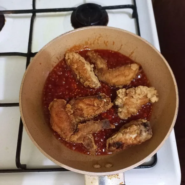 Masak saus hingga berminyak lalu masukkan ayam goreng, aduk hingga rata.