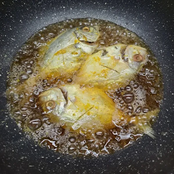 Panaskan minyak goreng, masukkan ikan. Goreng sampai ikan matang di kedua sisi. Angkat dan sisihkan.