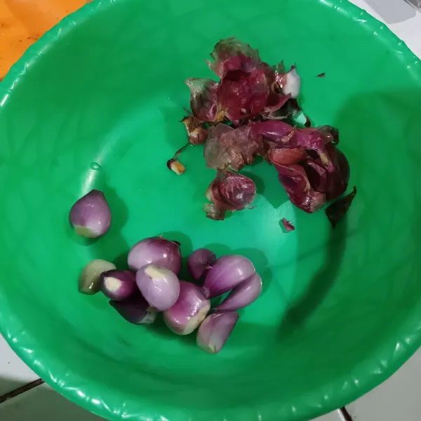 Lalu kupas bawang dengan pisau.