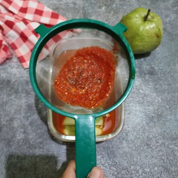 Saring bahan kuah ke dalam wadah berisi jambu kristal.