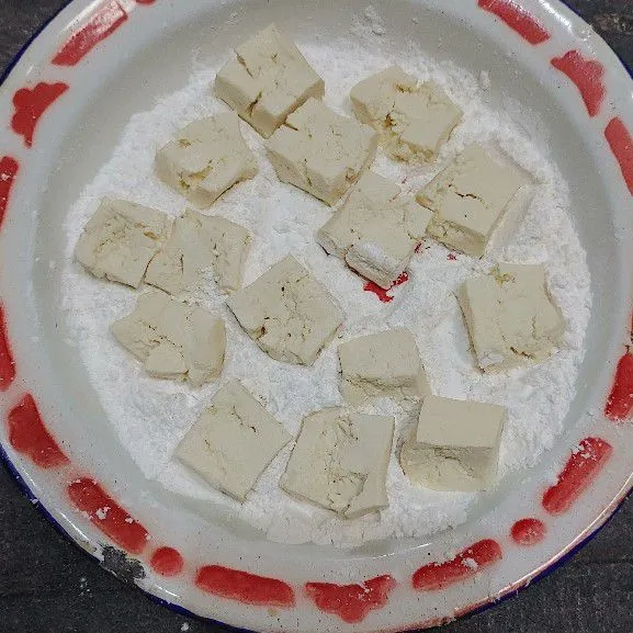 Masukan potongan tahu sambil agak dipenyet ke dalam tepung tapioka yang sebelumnya sudah ditambahkan kaldu bubuk terlebih dahulu.