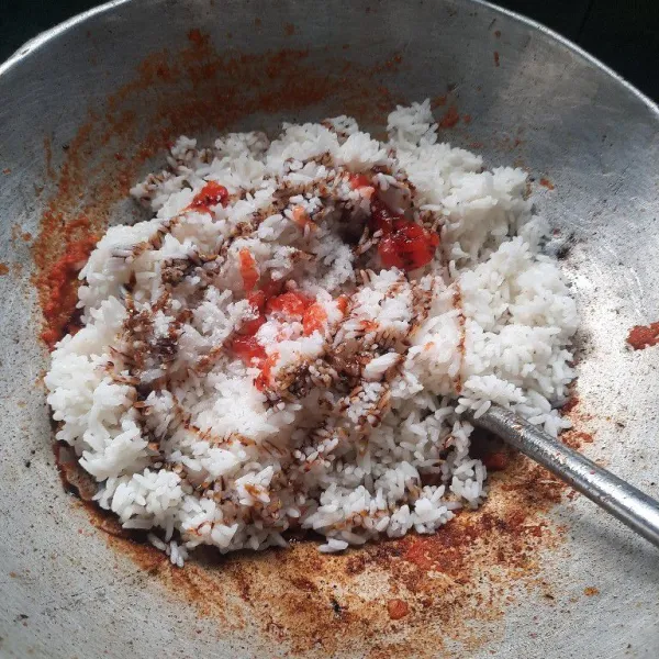 Masukan nasi, tambahkan saus sambal, kecap, garam dan kaldu bubuk aduk-aduk sampai nasi dan bumbu tercampur rata.