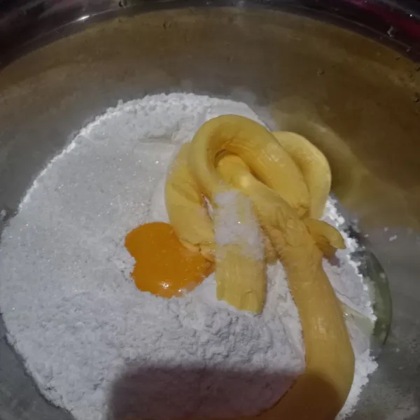 Masukkan ke wadah, tepung, kuning telur, garam, margarin, dan gula pasir. Aduk-aduk dengan sendok.
