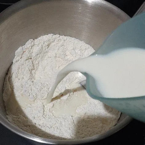 Aduk rata tepung, gula dan ragi instan kemudian tuangi susu sambil diuleni hingga kalis.