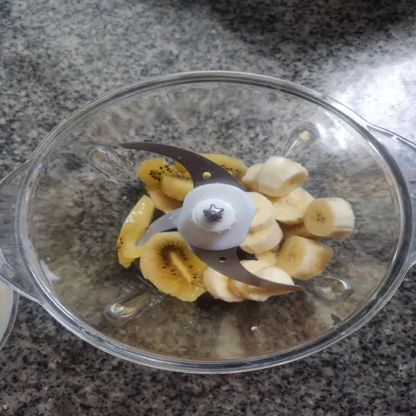 Masukkan buah pisang dan kiwi ke dalam blender.