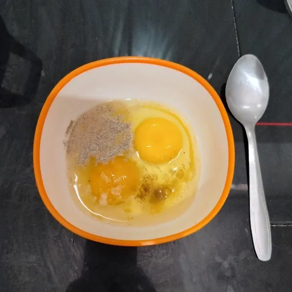 Pecahkan telur dalam mangkuk. Lalu tambahkan merica bubuk, kaldu bubuk, dan garam. Kocok hingga tercampur rata.