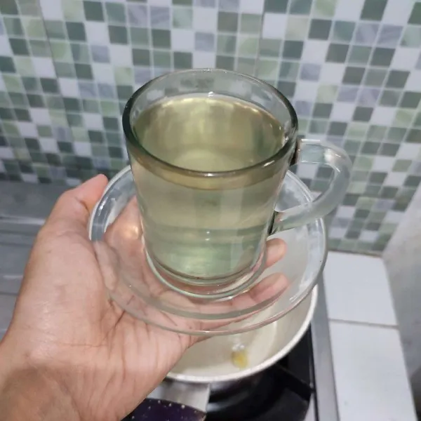 Tuang air rebusan jahe ke dalam gelas saji.
