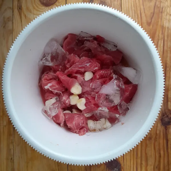 Potong-potong ikan tuna dan bawang putih, hancurkan es batu. Kemudian giling atau blender hingga menjadi halus dan lembut.