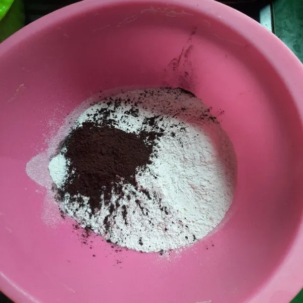 Campurkan tepung terigu dengan cokelat powder lalu tambahkan air, aduk-aduk sampai tepung larut.