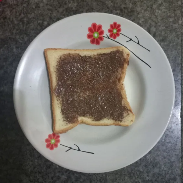 Olesi roti dengan cokelat oles, ratakan.