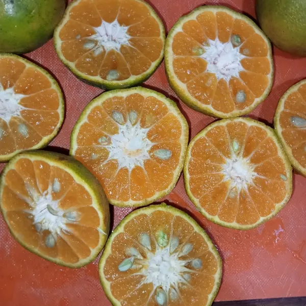 Belah jeruk masing masing menjadi dua.