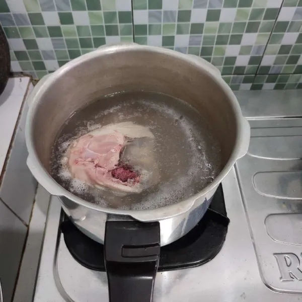 Rebus ayam dengan air, biarkan mendidih, buang busanya. Kalau ayam sudah empuk, matikan api, ambil ayamnya.