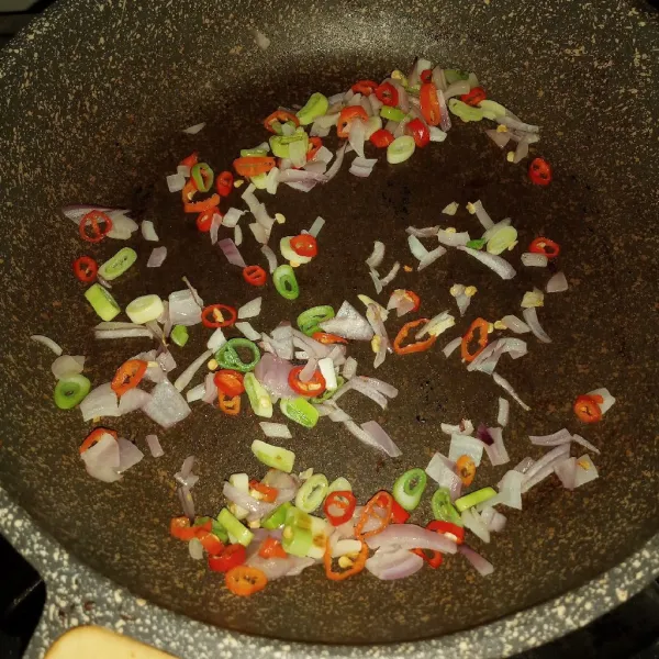 Panaskan secukupnya minyak, tumis bawang merah, daun bawang bagian putih dan cabe rawit. Tumis sampai layu.