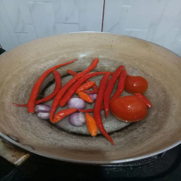 Rebus cabe merah, tomat, bawang merah sampai layu, lalu tiriskan.
