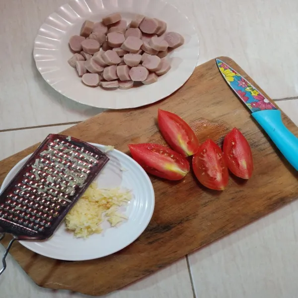 Potong 4 tomat, iris bulat/serong sosis dan parut bawang putihnya.