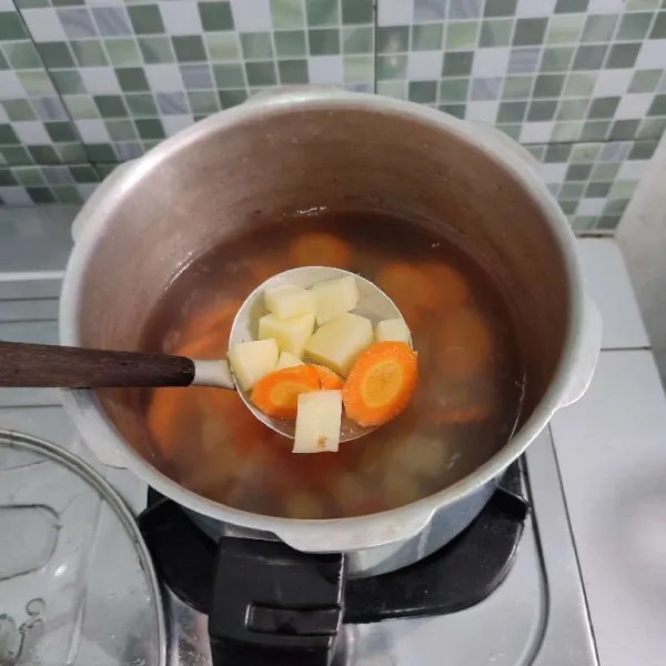 Didihkan kembali air kaldu ayam, jika sudah mendidih masukkan kentang dan wortel.
