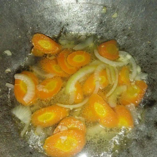 Masukkan wortel dan air, masak hingga wortel setengah matang.