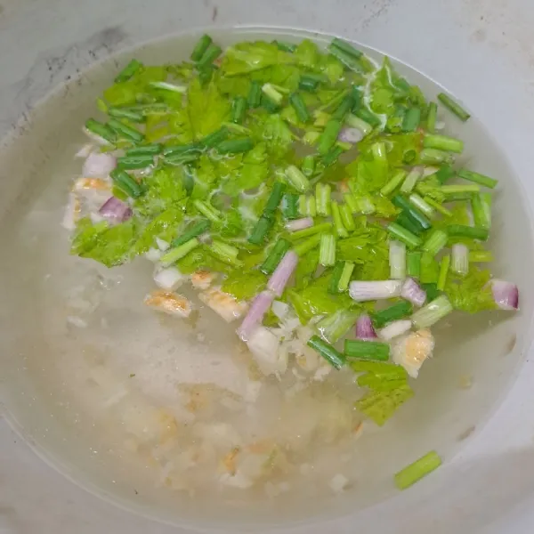 Rebus air, bawang putih cincang, jahe, daun bawang dan seledri sampai mendidih.