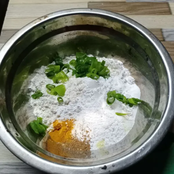 Dalam wadah masukkan terigu, tepung beras, daun bawang, kunyit bubuk, bawang putih bubuk, ketumbar bubuk, garam dan kaldu bubuk.