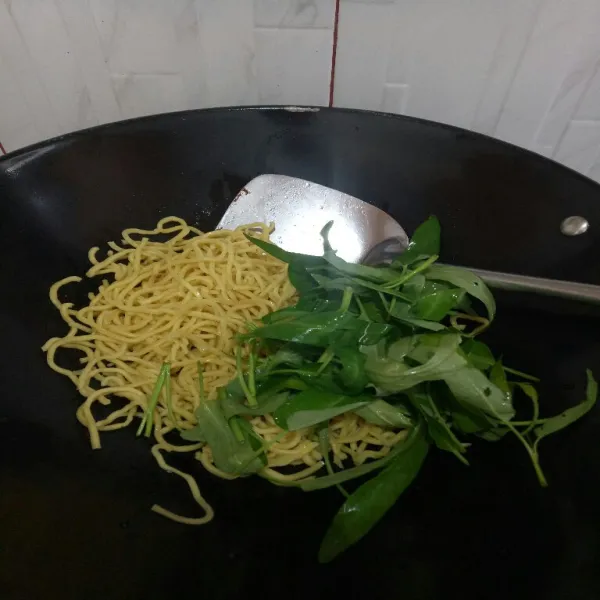 Masukkan mie kuning yang sudah direbus sebelum nya, masukkan sayur kangkung, aduk rata.