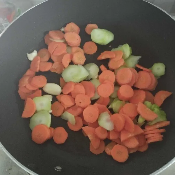 Masukkan potongan wortel dan bonggol brokoli, masak sampai matang.
