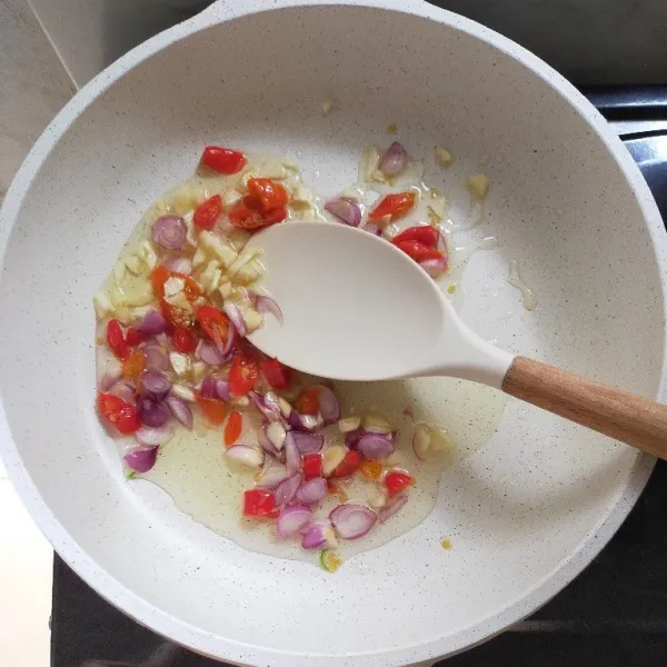 Tumis bawang merah, bawang putih dan cabai hingga layu.