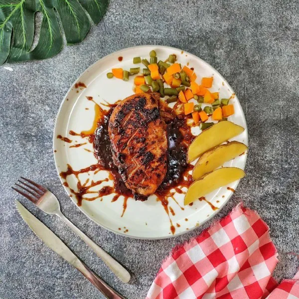 Tata chicken steak di atas piring saji, kemudian sajikan dengan saos blackpepper dan sayuran yang dikukus.