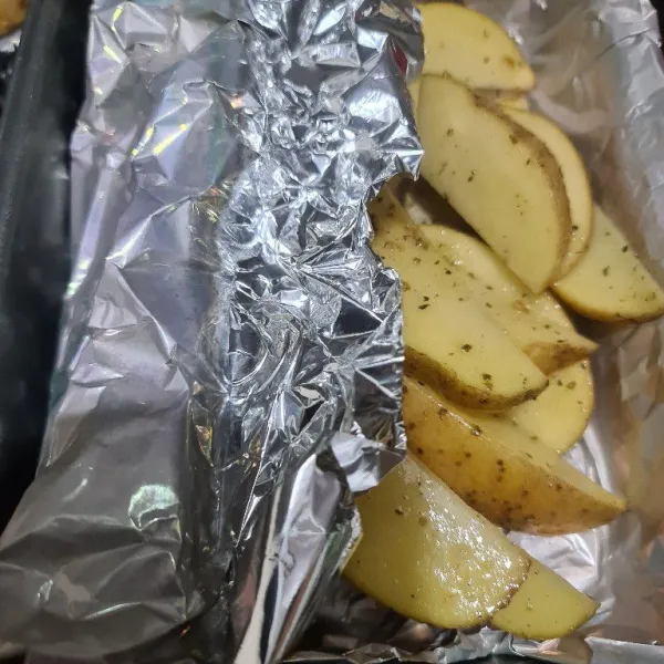 Beri aluminium foil pada loyang, masukkan kentang dan tutup dengan aluminium foil. Masukkan oven lalu panggang selama 30 menit ( hingga matang ).