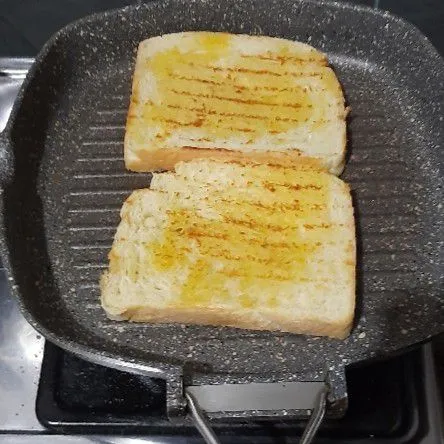 Panaskan margarin kemudian panggang roti.
