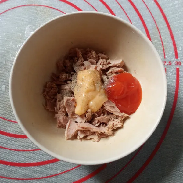 Peras ikan tuna dari air rendamannya. Letakkan di wadah. Tambahkan mayo dan saus tomat/ sambal. Taburi lada bubuk kemudian aduk rata.