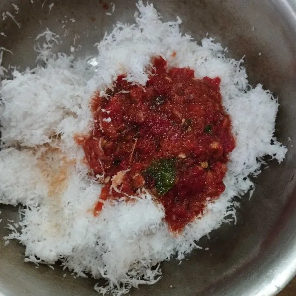 Dalam wadah, masukkan kelapa parut. Tambahkan bumbu yang sudah halus.