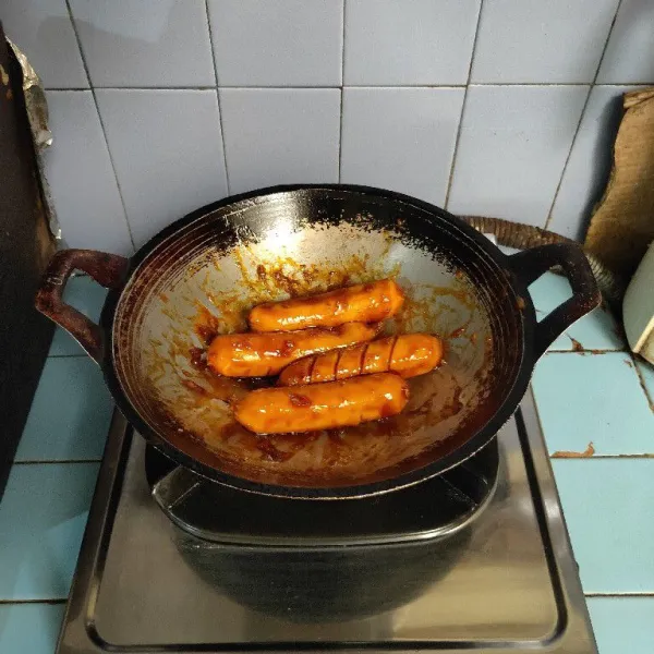 Aduk sosis hingga bumbu tercampur rata. Masak dengan api kecil hingga bumbu meresap.