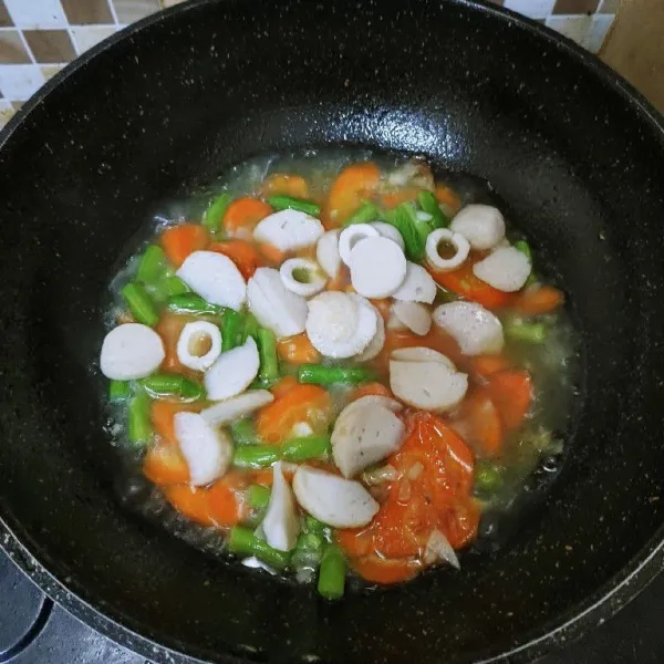 Tambahkan air, masak sampai wortel dan buncis matang serta air mendidih. Lalu masukan bakso ikan yang sudah diiris-iris.