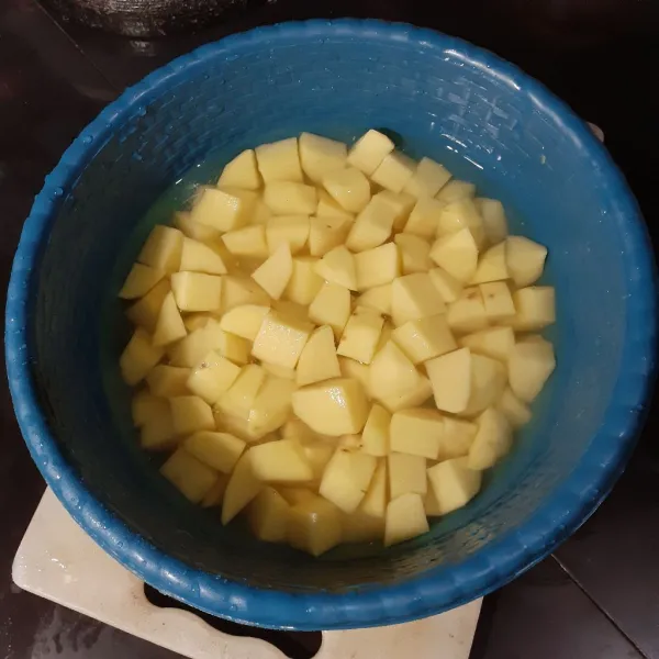 Kupas kentang, cuci bersih, lalu potong dadu. Rendam dalam secukupnya air yang diberi sedikit garam.