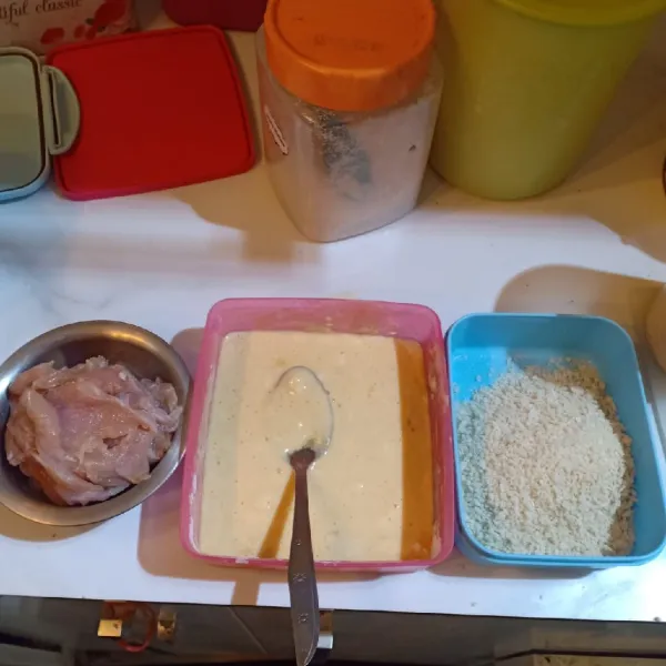 Siapkan bahan untuk membuat chicken katsu. Campur tepung terigu, garam dan bubuk bawang putih lalu tambahkan air, aduk rata.